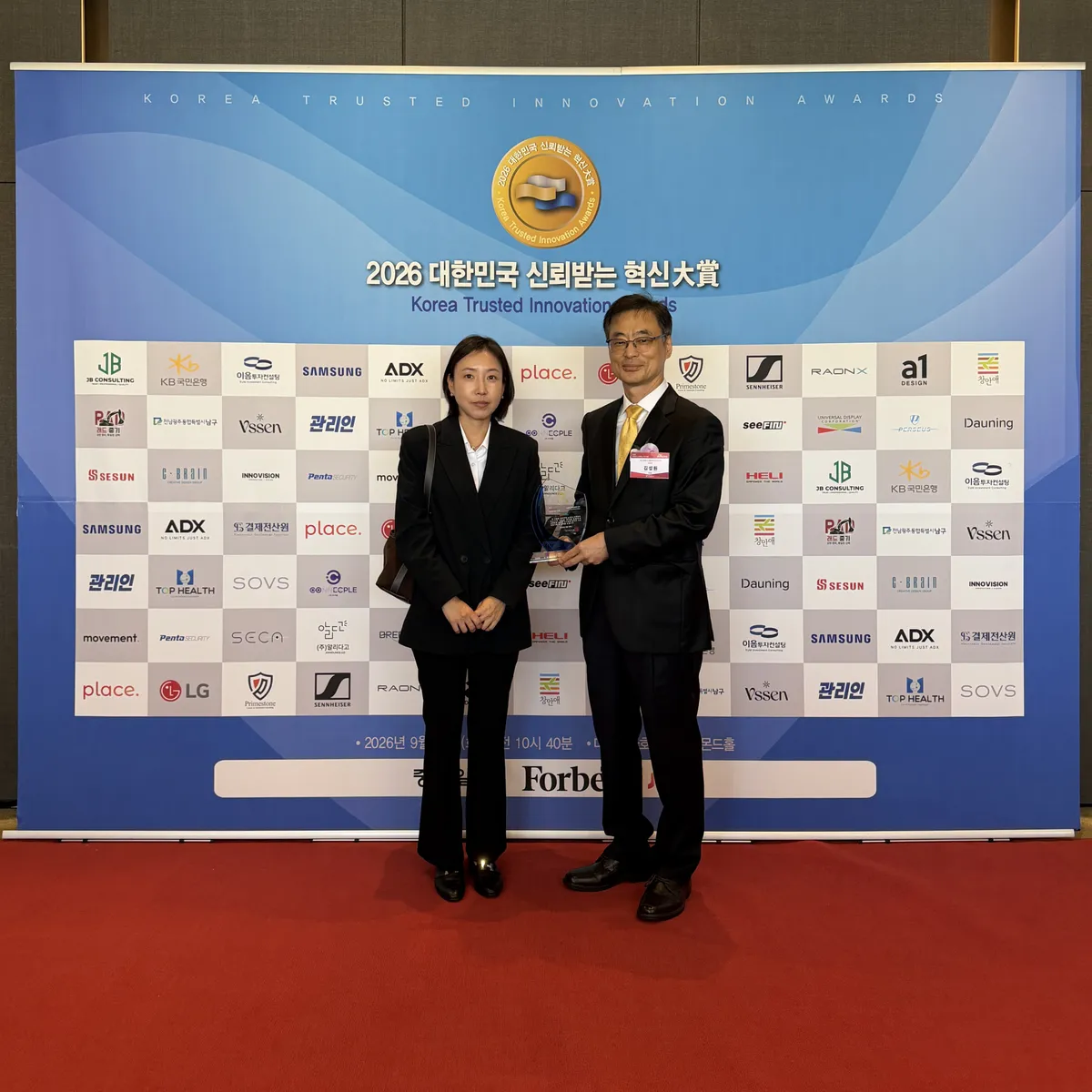 ‘2026 대한민국 신뢰받는 혁신대상’ 시상식에 참석한 UDC Korea의 홍은선 부장(왼쪽)과 김성원 전무