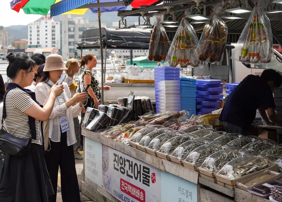 ‘어(魚)메이징 크루’ 참가자들이 통영중앙시장 건어물 거리에서 크기와 용도에 따라 판매되는 다양한 멸치를 살펴보고 있다