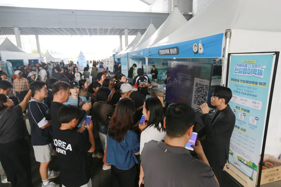 천일염이력제 홍보관을 찾은 관람객들이 휴대폰으로 퀴즈를 풀며 ‘천일염이력제 퀴즈쇼’에 참여하고 있다