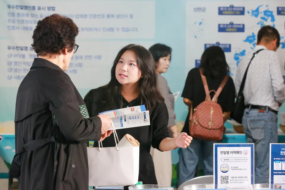 천일염이력제 홍보관을 찾은 관람객이 ‘국가별 천일염 비교’ 코너에서 국산 천일염의 특징과 이력 확인 방법에 대한 설명을 듣고 있다